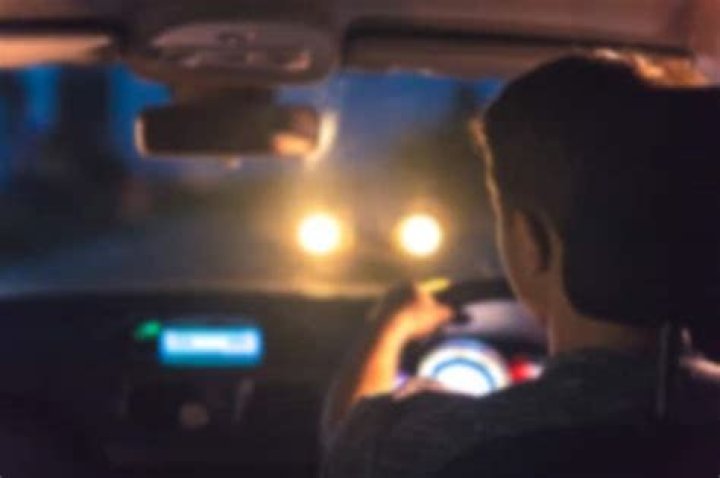 When a car with bright lights comes towards you at night you should?