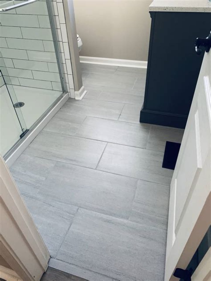 Which way should tile be laid in a small bathroom?